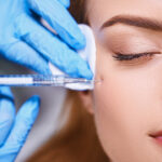 Young female is preventing wrinkles on her face by getting a liquid facelift.